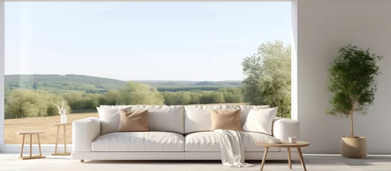 Foto op Plexiglas Minimalist living room with white sofa and view of summer landscape through window. Scandinavian decor. © Vusal