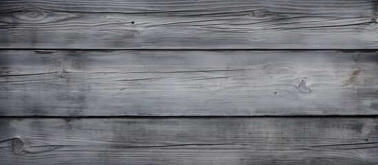 A close up of a rectangular grey hardwood plank flooring surface with tints and shades, showcasing a pattern of parallel lines on a composite material