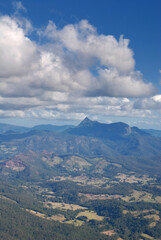 From Springbrook NP, Queensland, a stunning vista reveals Mount Warning amid lush rainforest, misty valleys, and distant horizons