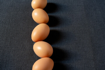 Fresh brown chicken eggs on grey background.