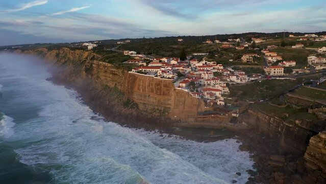 White Houses of Azenhas do Mar Village in Portugal. Cliffs and Waves of Atlantic Ocean. Aerial View. Orbiting