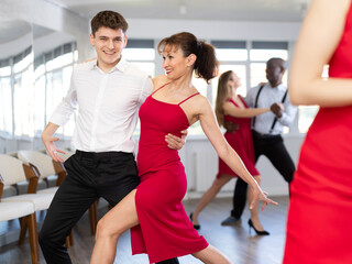 Energy man and woman are dancing tango in couple during lesson at studio. Leisure activities and...
