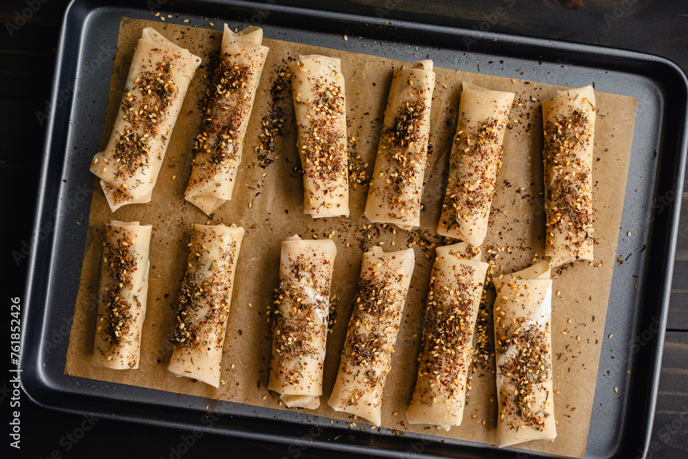 Wall mural unbaked za'atar spring rolls on a sheet pan: spring roll appetizers with halloumi cheese and mint to