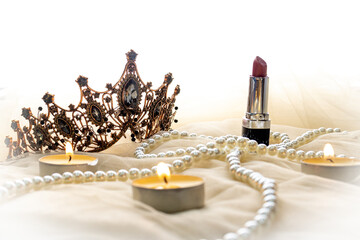 crown and pearls with lipstick and candles