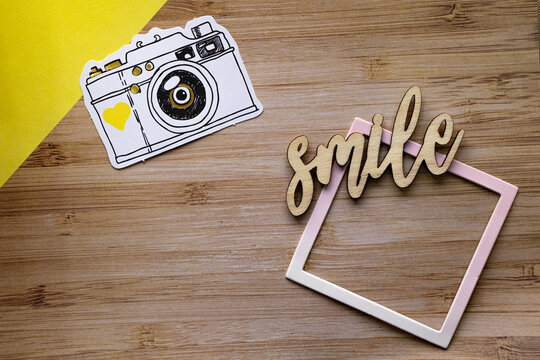camera and frame on wooden background