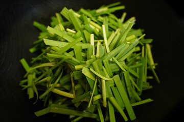 A black plate full of fresh chives