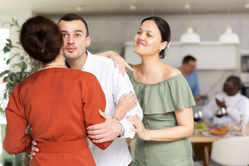 Man and woman greet each other when meeting in kitchen at home