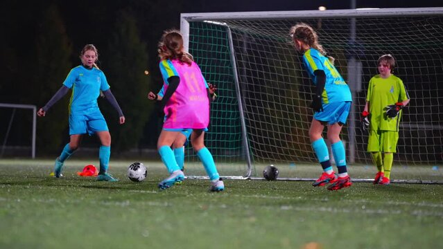 young girls in uniforms having a practice at night in a stadium. High quality 4k footage