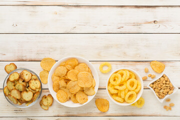 Different tasty snacks with sauce on wooden background, top view