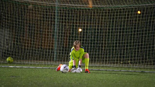 young goalkeeper girl getting ready to catch a ball at a match, young girls team. High quality photo