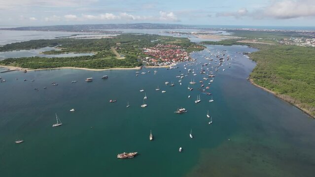 Forward reveal drone shot of roadstead in Keramba Wayan Apel Strait on sunny day. Serangan, Denpasar, Bali.