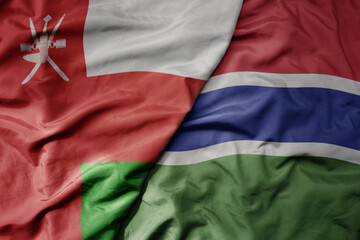 big waving national colorful flag of gambia and national flag of oman.