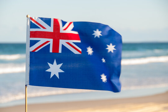 Discover the pride of Australia with a small flag adorning Moreton Island's Queensland beach. A patriotic touch amidst coastal beauty