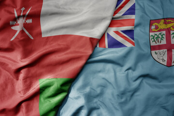 Fototapeta premium big waving national colorful flag of Fiji and national flag of oman.