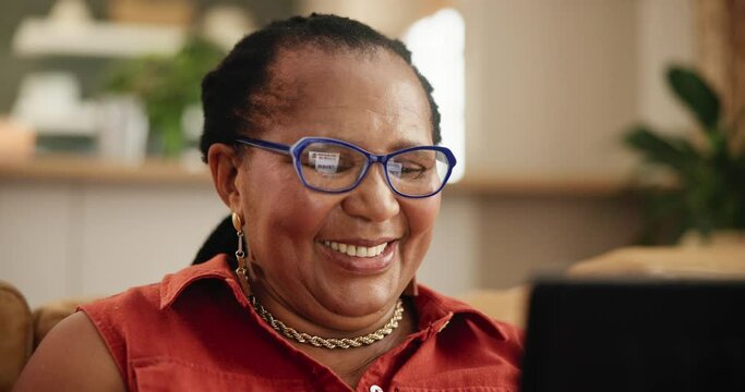 Tablet, glasses and senior black woman on a sofa reading ebook, social media or meme gif at home. Digital, app and face of old African person with online comic, show or Netflix and chill in a house