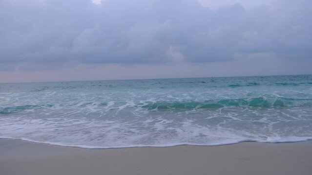 The sky was covered with gray clouds and the sea has slight waves.