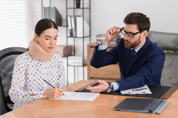 Fototapeta premium Injured woman signing document in lawyer's office