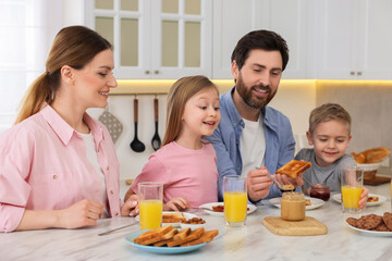 Obraz na płótnie Canvas Happy family having breakfast at table in kitchen