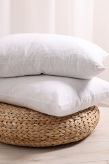 Soft pillows on wicker pouf in room