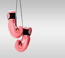Breast cancer awareness. Pair of pink boxing gloves on light grey background, space for text