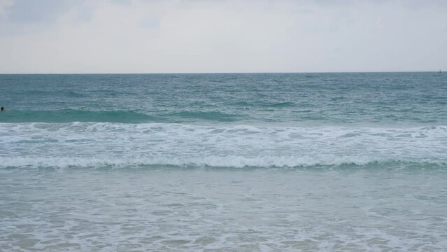 sea blue waves crashing on the sandy beach.