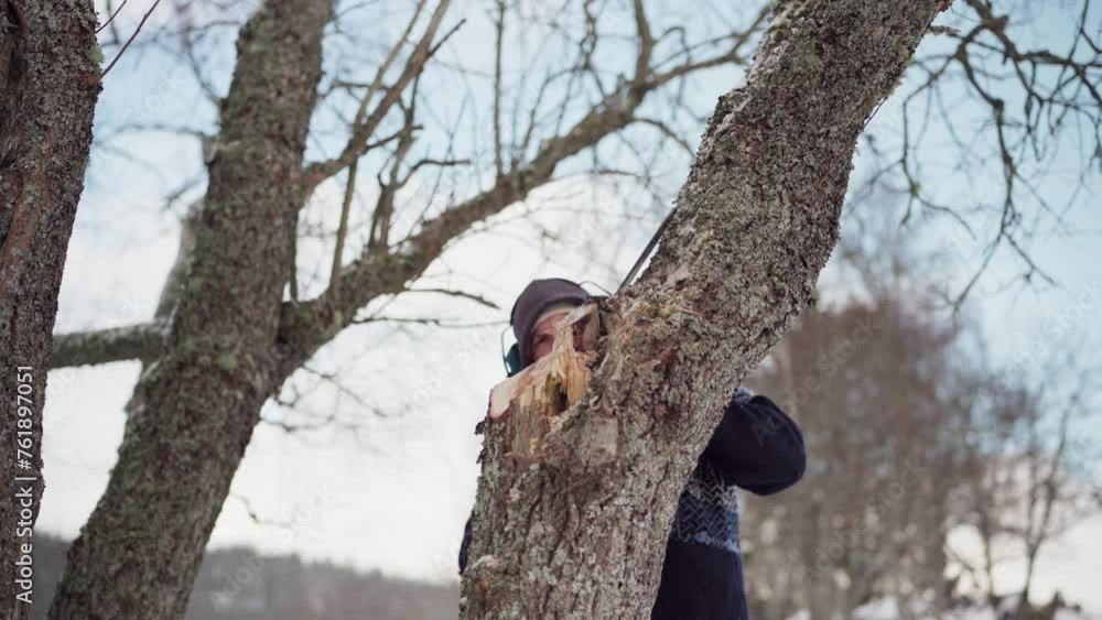 Aufkleber guy in headphone while cutting tree trunk with a chainsaw. - close up shot