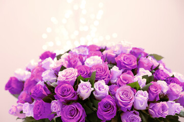 Bouquet of violet roses against blurred background, closeup. Funeral attributes