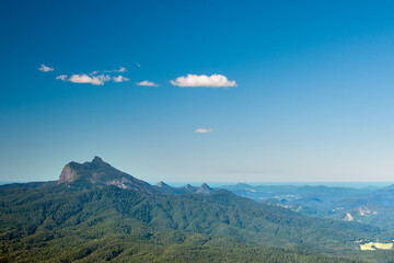 Majestic Mount Warning stands tall, framed by the vast Pacific Ocean, creating a stunning contrast of land and sea.