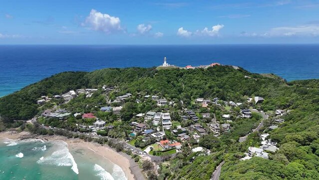 Wategos beach of Byron Bay with green cliff, buildings, lighthouse, sea and blue sky in Australia