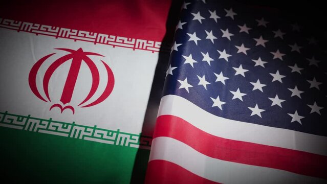 United States and Iran country flags on turntable on dark background