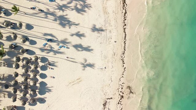 4K Aerial drone top view crowd of people at tropical Beach with sunset in Punta Cana, Dominican Republic, Beautiful beach is famous tourist destination at Caribbean sea. Top view happy people play 
