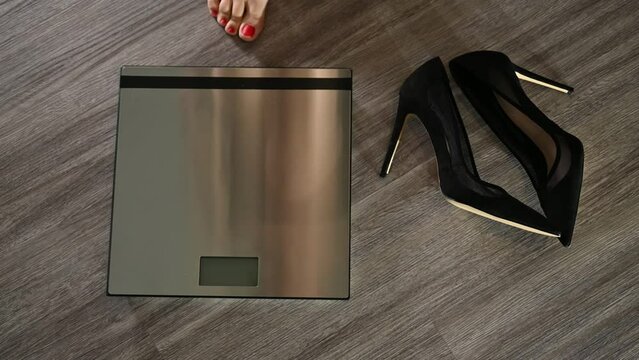Elegant women taking her high hill shoes off and stepping on bathroom scale. 4K Resolution