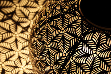 Abstract geometric light pattern from solar light globe or lantern. Beautiful yellow black hollowed design from an ornamental solar outdoor night light. Selective focus with defocused shapes.