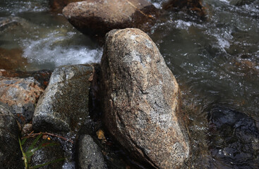 Clear water flows in a river between the rocks