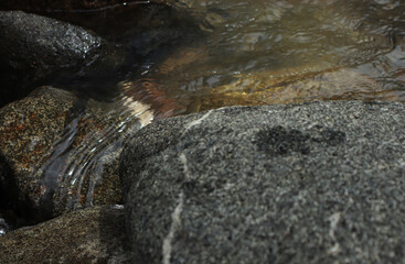 Clear water flows in a river between the rocks