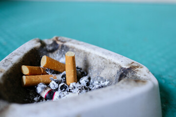 a dirty ashtray with several ciggarettes