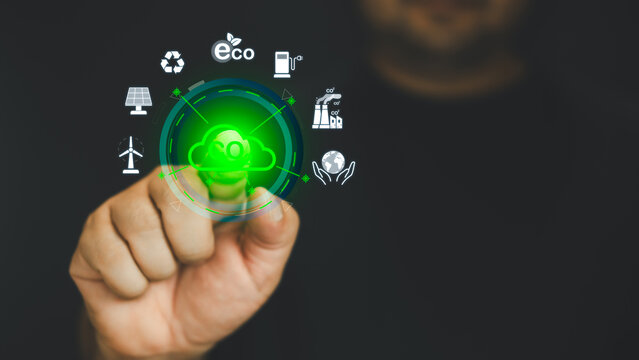 Hand points to a touchscreen CO2 icons and an icon renewable energy for reduce CO2 emission on virtual screen, net zero carbon, global warming, green fuel and earth protect
