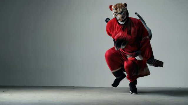 Figure in red ninja attire, wielding a sword with one hand, standing in a confrontational pose.

