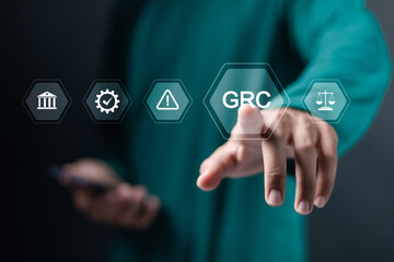 GRC, Governance Risk and Compliance. Process for managing future uncertainties that will have an impact on the organization. Person touching GRC icon on virtual screen.