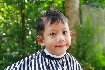 Cutting hair of Asian little boy with barber scissors in the garden. - 761951061