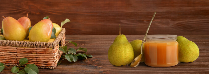 Basket with fresh pears and jar of tasty jam on wooden background