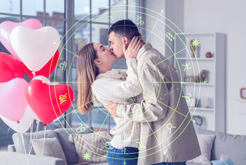 Beautiful young couple with heart-shaped balloons kissing and celebrating Valentine's Day at home