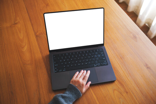 Top view mockup image of a woman working  on laptop computer with blank screen on wooden table