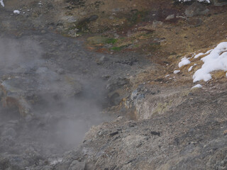 Volcanic landscape with thermal pool and steam rising from hot soil, Baransky volcano on Iturup, Kuril islands