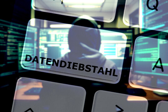 Ein Hacker am Computer, eine Tastatur und Datendiebstahl