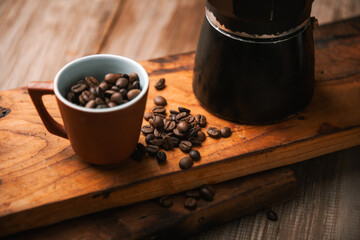 coffee cup and coffee beans on wood with old books in the background