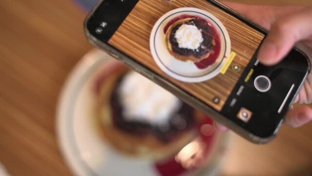 Food Blogger Taking Picture Of Vegan pancakes For Breakfast with blue berries Using Smartphone