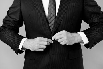 Businessman buttoning his suit in black and white