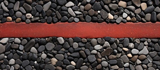 Red line running across black and white pebbles