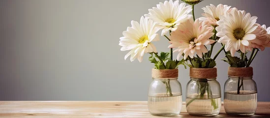 Fototapeten Three vases with assorted flowers on a table © Ilgun